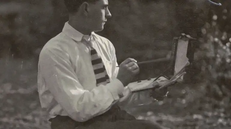 Fotografía en blanco y negro de Gregorio Prieto pintando al aire libre hacia 1919, con paleta y caballete de campo