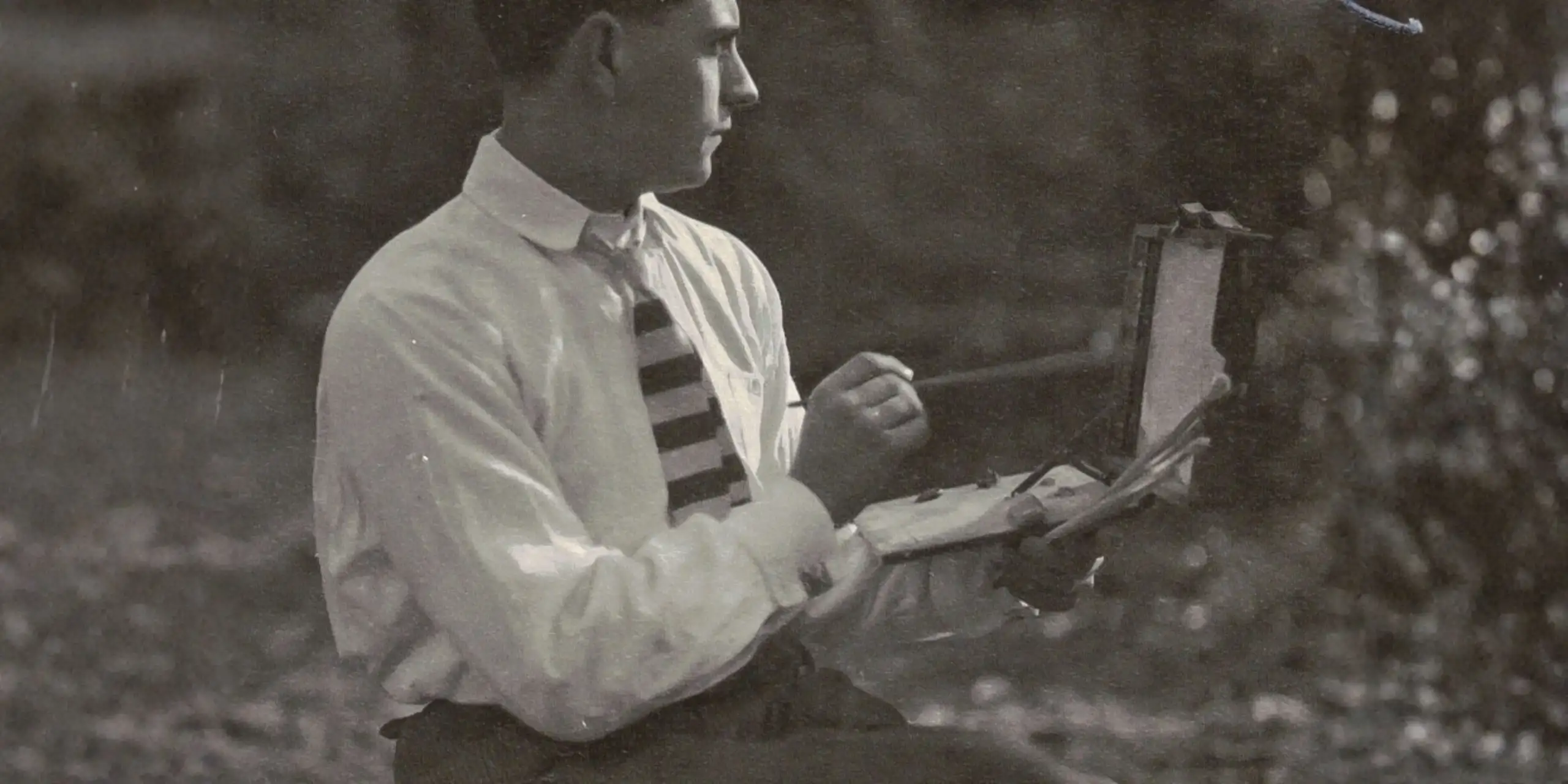 Fotografía en blanco y negro de Gregorio Prieto pintando al aire libre hacia 1919, con paleta y caballete de campo